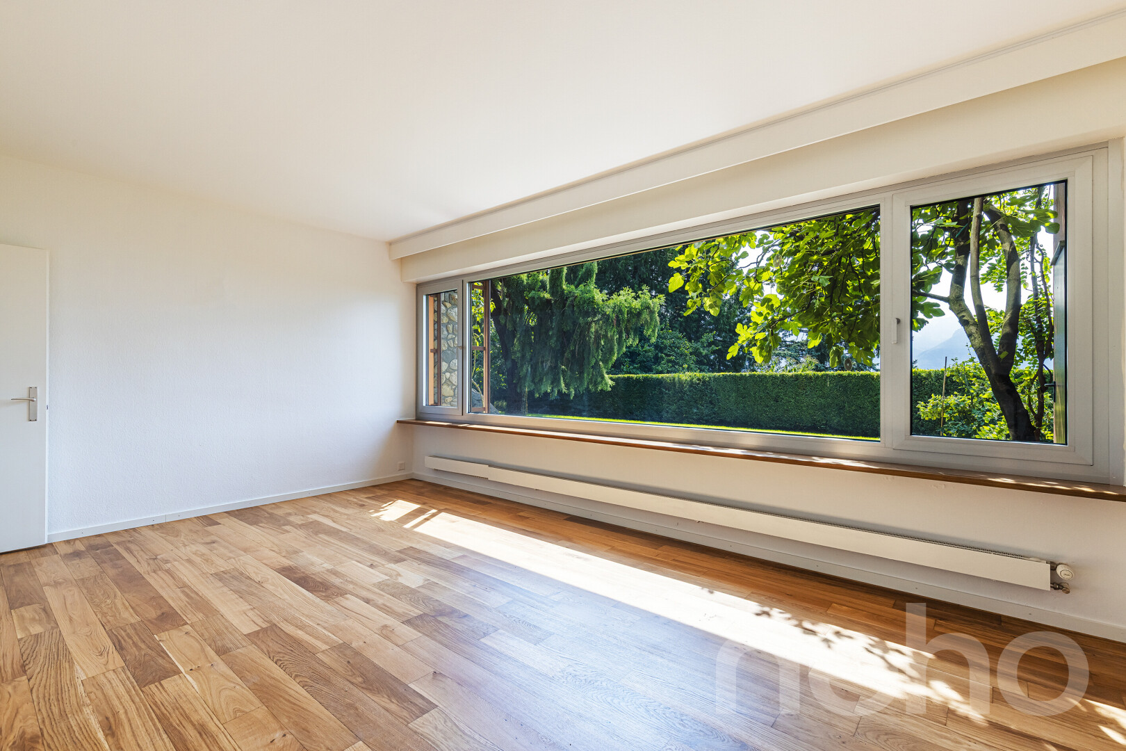 pièce vide avec radiateur à plinthe, cloison sèche, drywall, inside property, et sol en finition bois