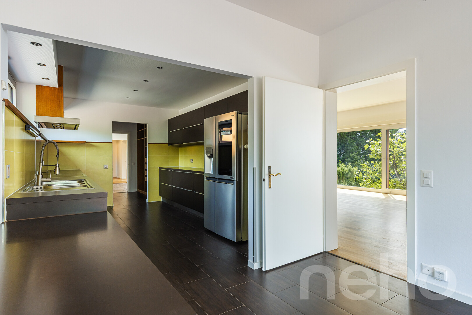 cuisine avec wood finish floor, sol en finition bois, réfrigérateur, natural light, et lumière naturelle