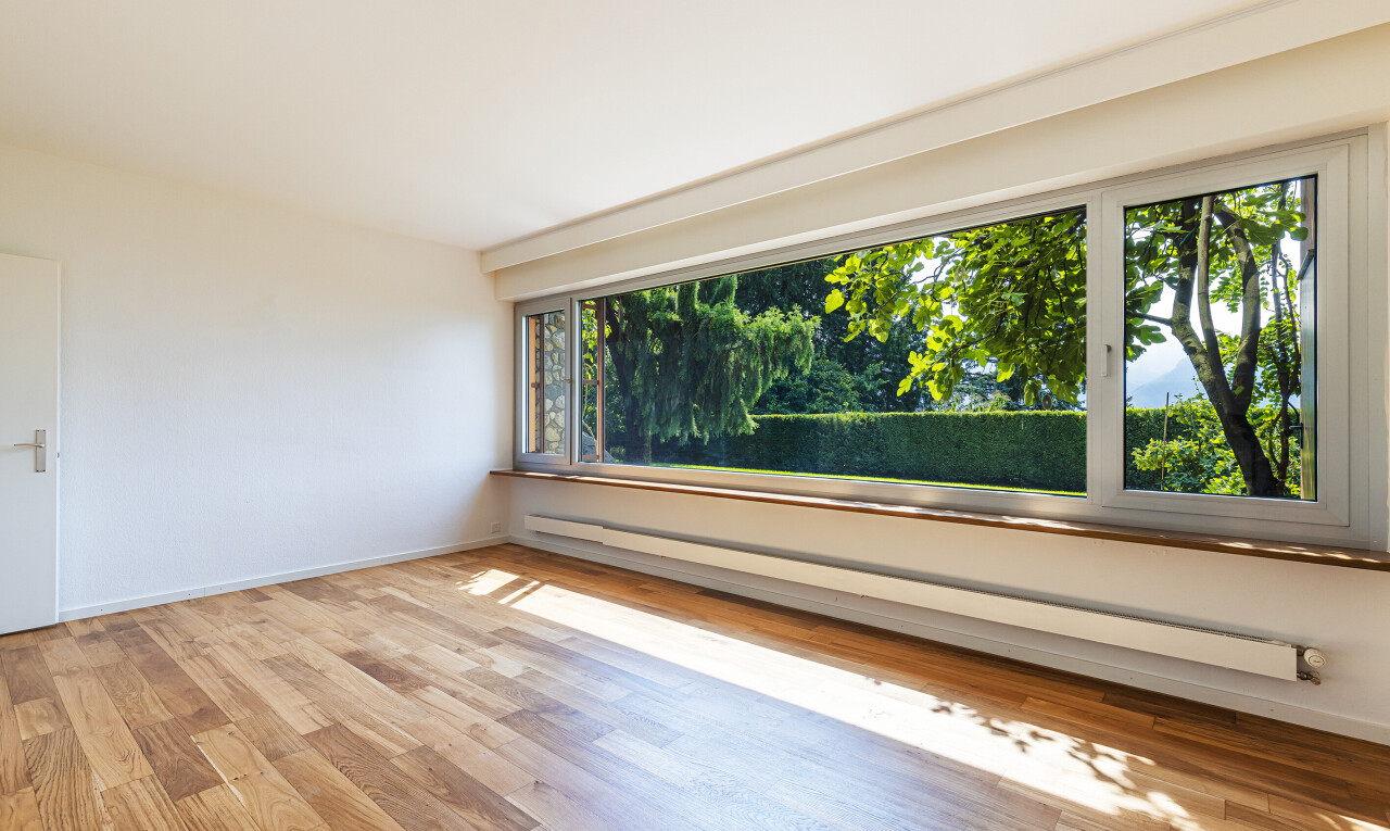 pièce vide avec radiateur à plinthe, cloison sèche, drywall, inside property, et sol en finition bois