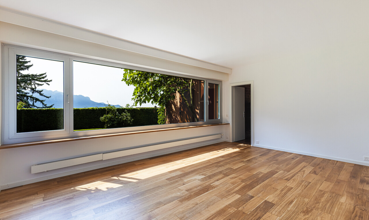 leerer raum mit fußleistenheizung, wood finish floor, holzfußboden, inside property, und drywall