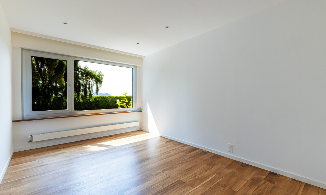 leerer raum mit inside property, fußleistenheizung, wood finish floor, holzfußboden, und natural light
