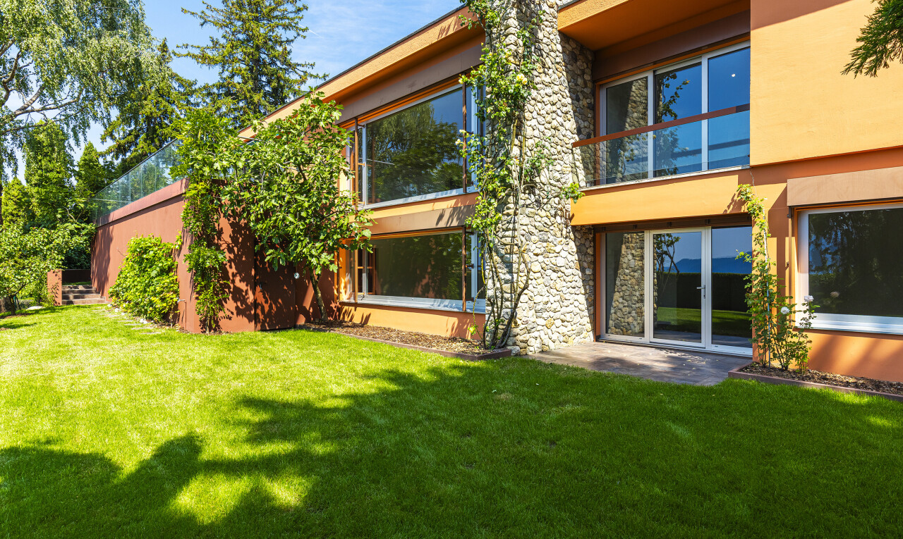 außenansicht mit balkon, steinverkleidung, property visible, rasen, und day time