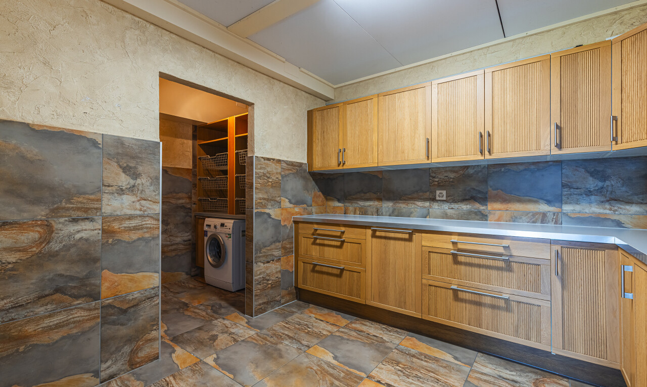 cuisine avec armoires de style shaker, inside property, sol en finition pierre, stone finish floor, et lave-linge et sèche-linge