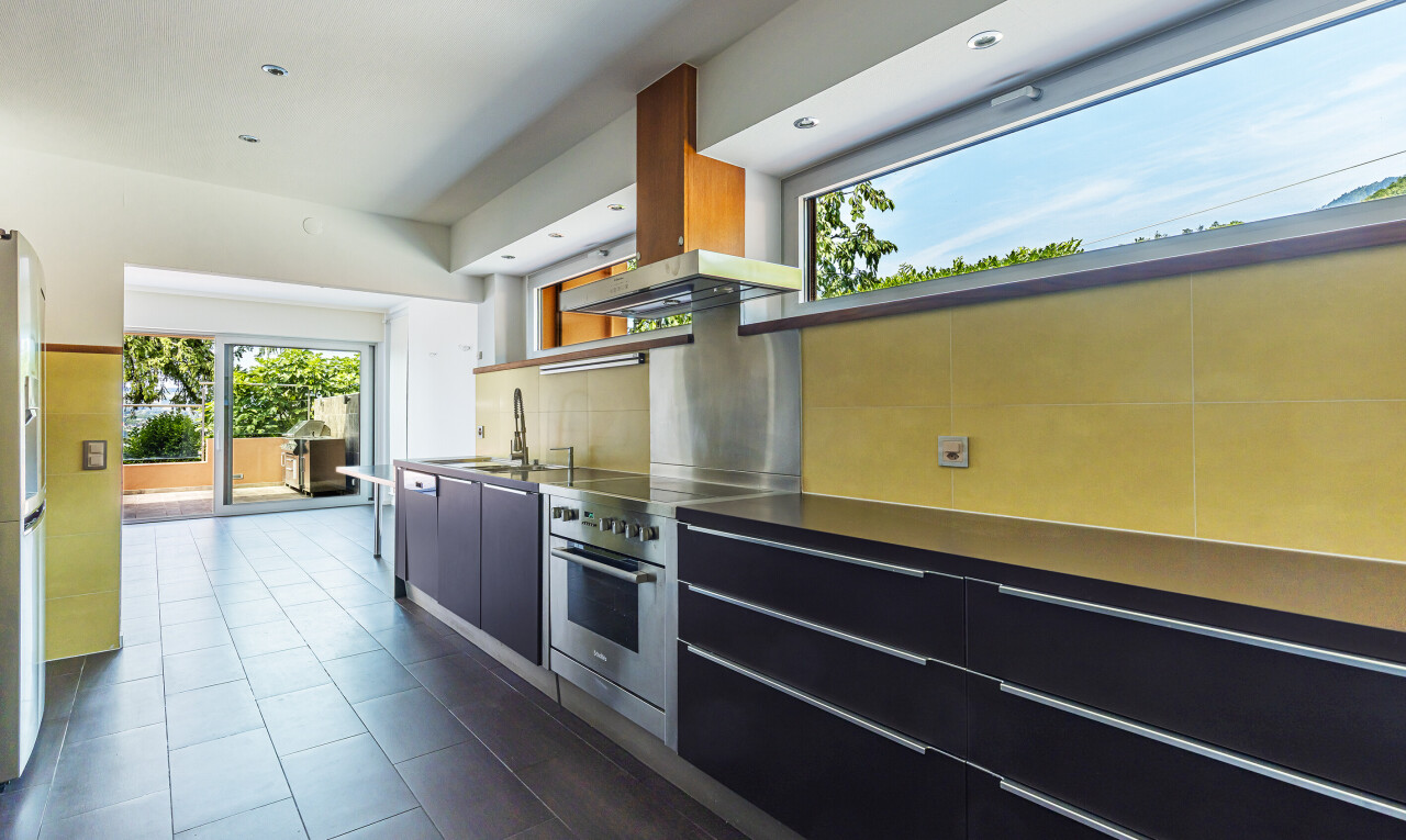 cuisine avec natural light, lumière naturelle, armoires noires, armoires à panneau plat, et inside property