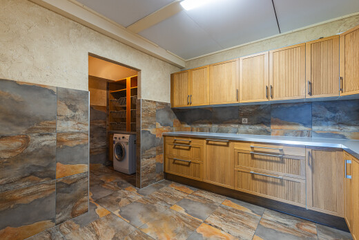 cuisine avec armoires de style shaker, inside property, sol en finition pierre, stone finish floor, et lave-linge et sèche-linge