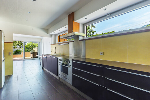 cuisine avec natural light, lumière naturelle, armoires noires, armoires à panneau plat, et inside property