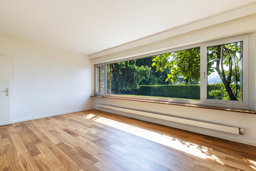 pièce vide avec radiateur à plinthe, cloison sèche, drywall, inside property, et sol en finition bois