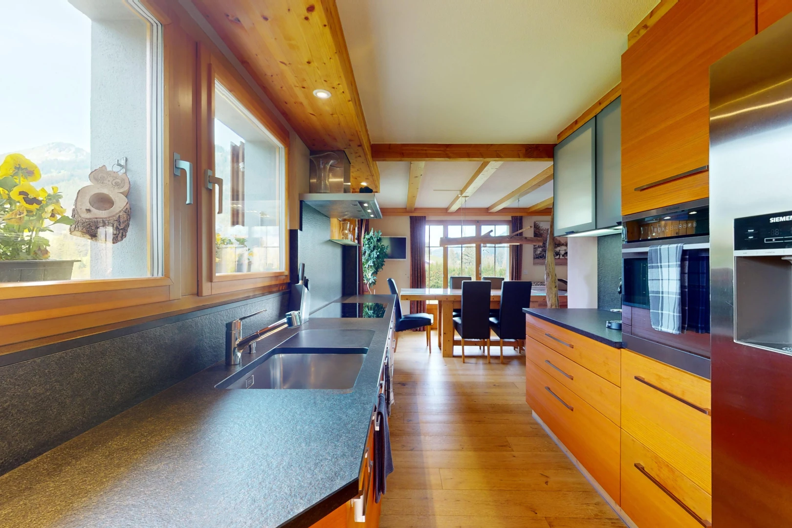 cuisine avec évier, réfrigérateur, wood finish floor, sol en finition bois, et natural light