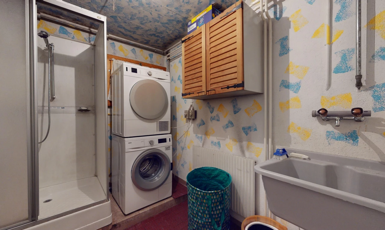 buanderie avec lave-linge et sèche-linge superposés, mur en papier peint, wallpaper wall, et inside property