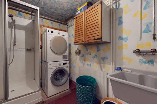 buanderie avec lave-linge et sèche-linge superposés, mur en papier peint, wallpaper wall, et inside property