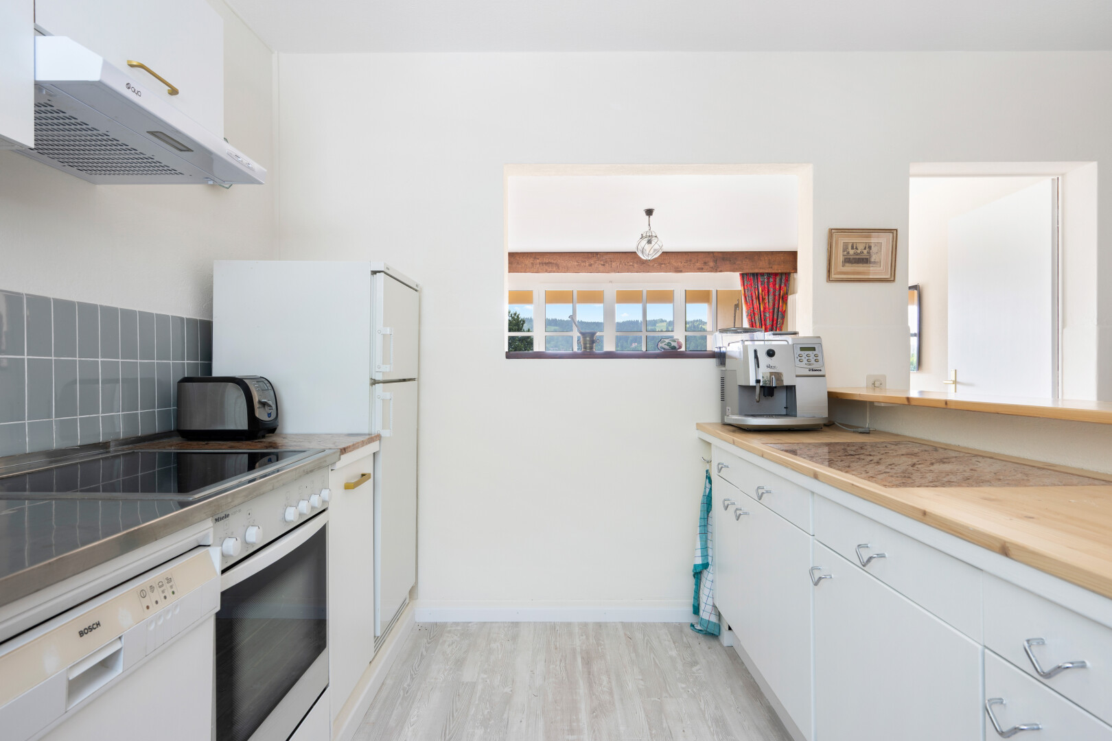 cuisine avec armoires blanches, white cabinets, hotte, four, et light floor