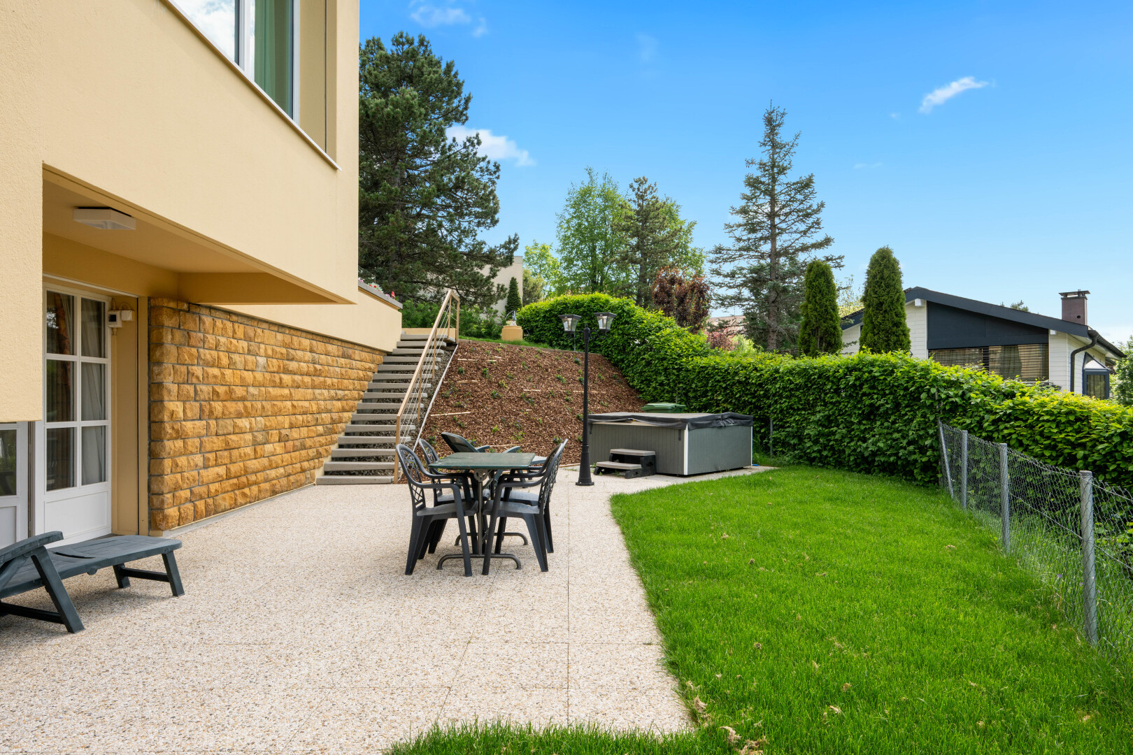 terrasse avec escaliers, bain à remous, terrasse, coin repas extérieur, et clôture