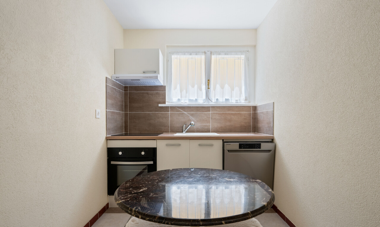 cuisine avec mur texturé, textured wall, four, inside property, et light floor
