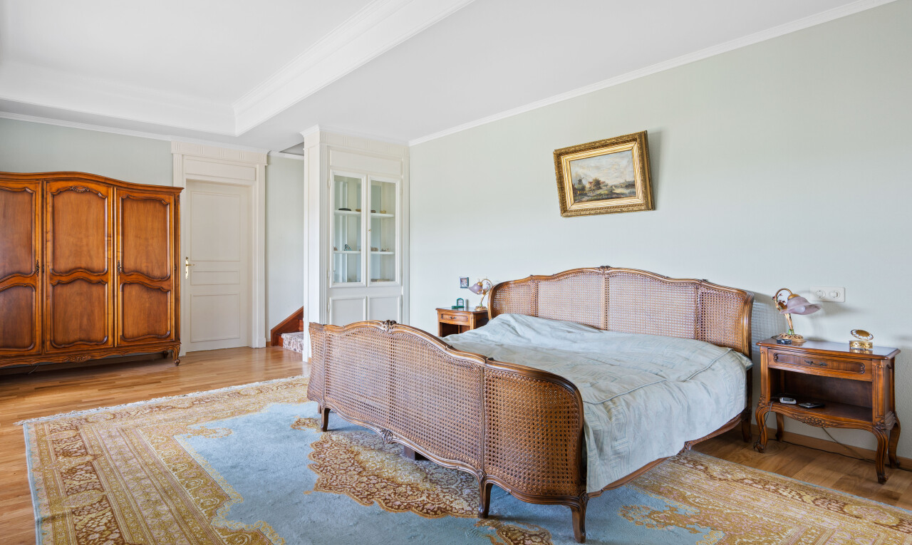 chambre avec wood finish floor, sol en finition bois, drywall, cloison sèche, et crown molding