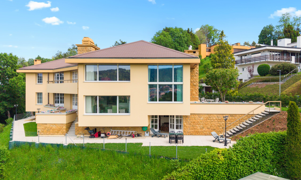 outdoor house featuring a patio area, a chimney, and stucco siding