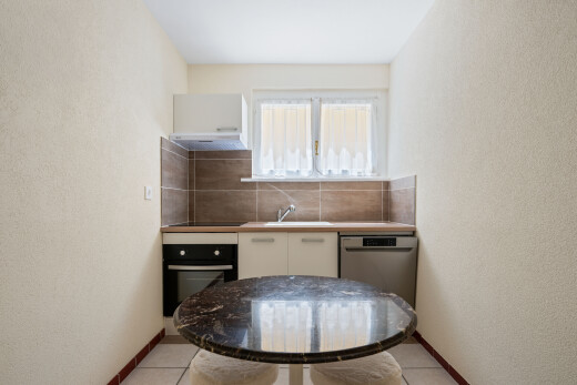 cuisine avec mur texturé, textured wall, four, inside property, et light floor