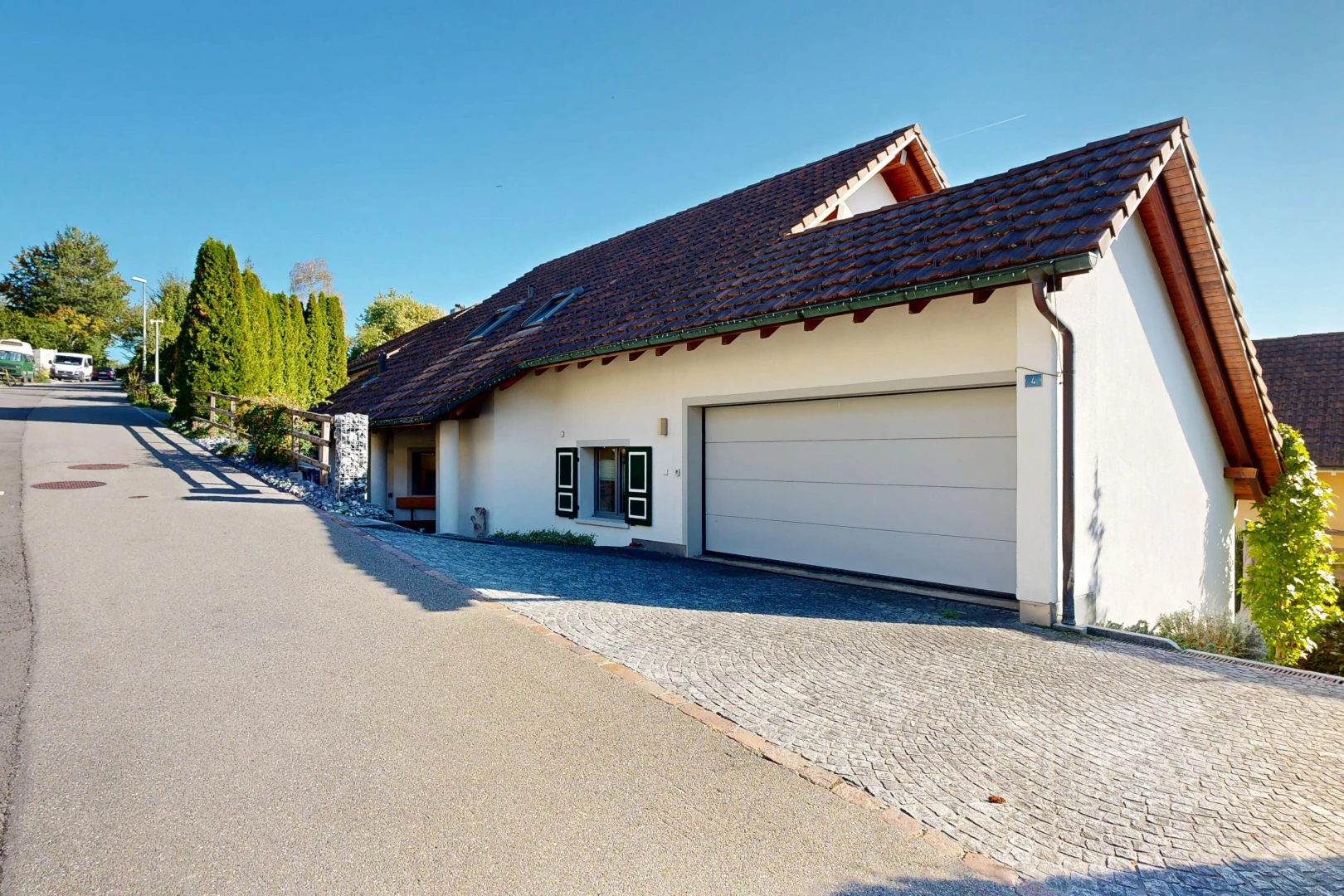außenansicht mit ziegeldach, day time, garage angeschlossen, stuckverkleidung, und auffahrt