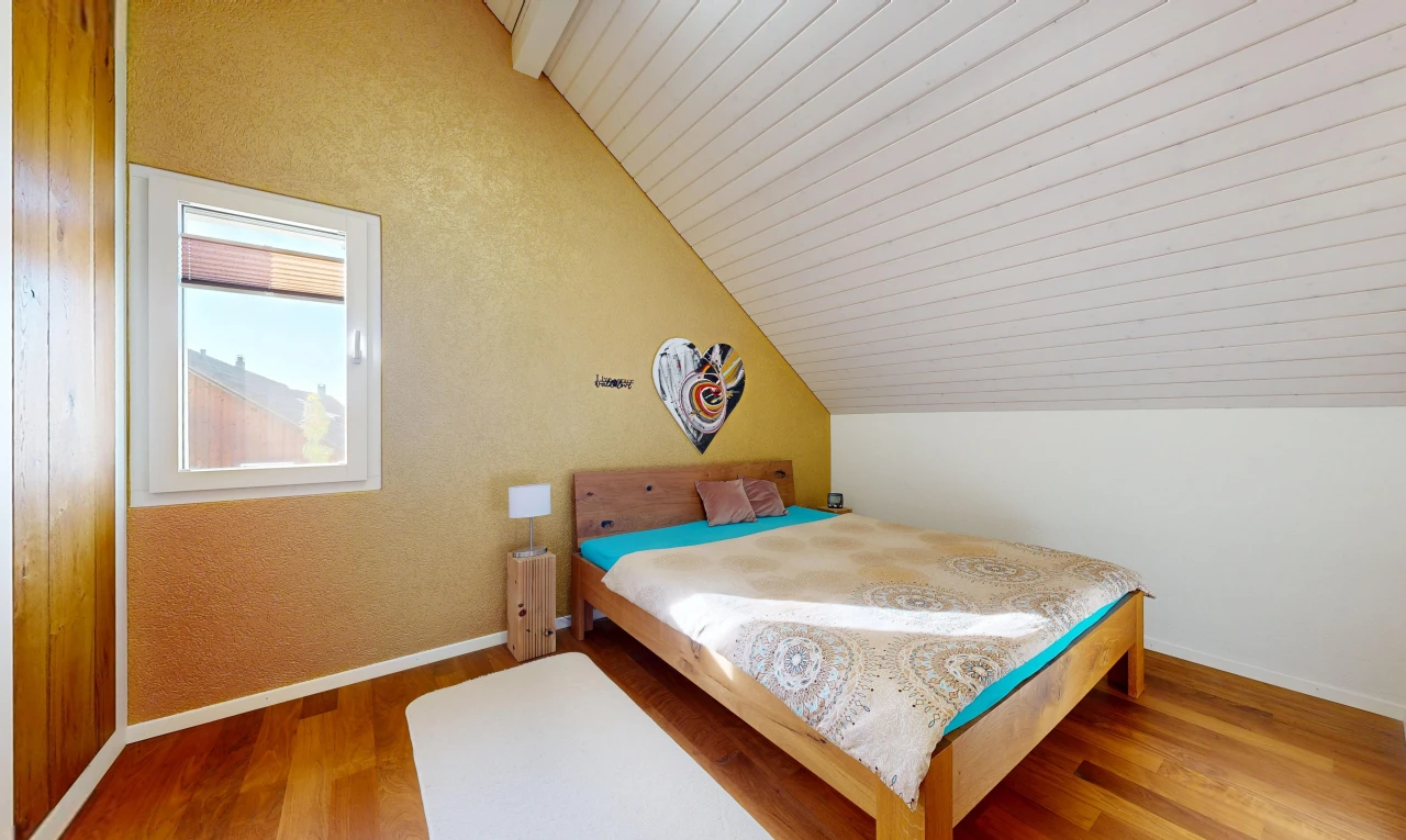 zimmer / schlafzimmer mit zusätzliches zimmer, vaulted ceiling, dachschräge, wood finish floor, und holzfußboden