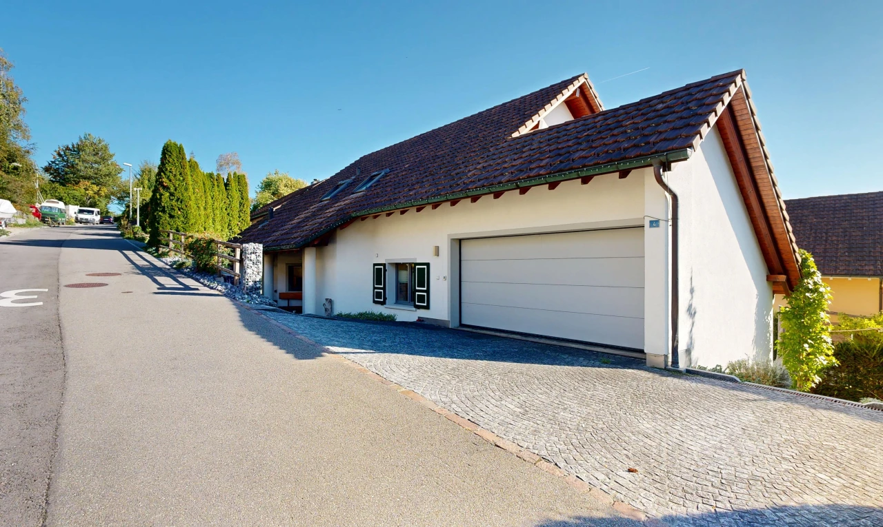 außenansicht mit ziegeldach, day time, garage angeschlossen, stuckverkleidung, und auffahrt
