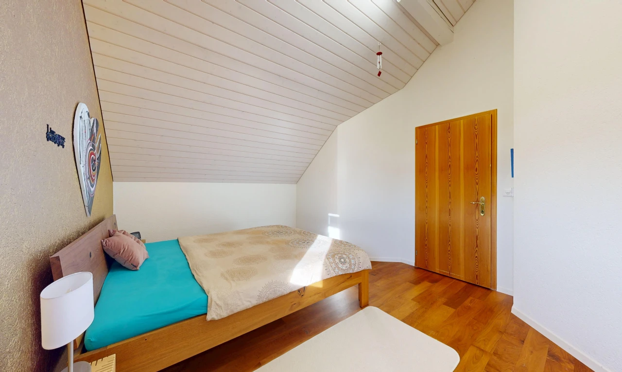 zimmer / schlafzimmer mit zusätzliches zimmer, vaulted ceiling, dachschräge, wood finish floor, und holzfußboden