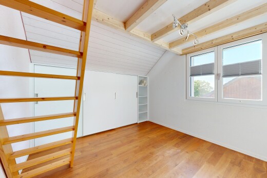 empty room featuring light wood-style floors, lofted ceiling with beams, and track lighting