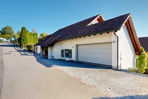 view of home featuring a tiled roof, an attached garage, stucco siding, and driveway