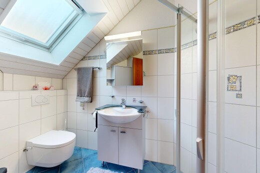 full bath featuring tile walls, vanity, vaulted ceiling, a stall shower, and tile patterned floors