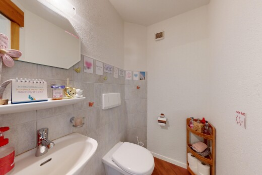half bath featuring wood finished floors and tile walls