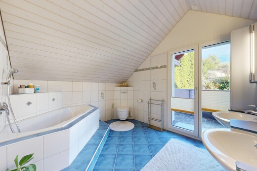 bathroom featuring a garden tub, vaulted ceiling, tile walls, and tile patterned floors