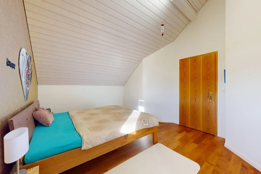 zimmer / schlafzimmer mit zusätzliches zimmer, vaulted ceiling, dachschräge, wood finish floor, und holzfußboden