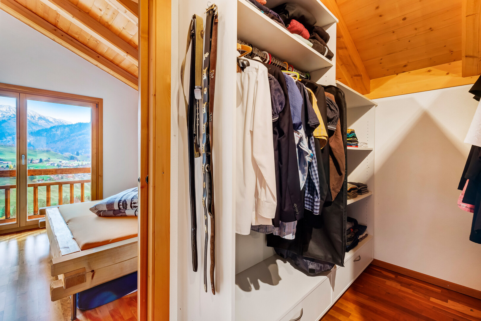 begehbarer kleiderschrank mit wood finish floor, holzfußboden, vaulted ceiling, und dachschräge
