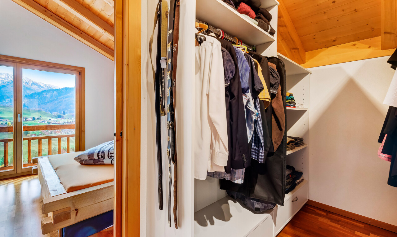 begehbarer kleiderschrank mit wood finish floor, holzfußboden, vaulted ceiling, und dachschräge