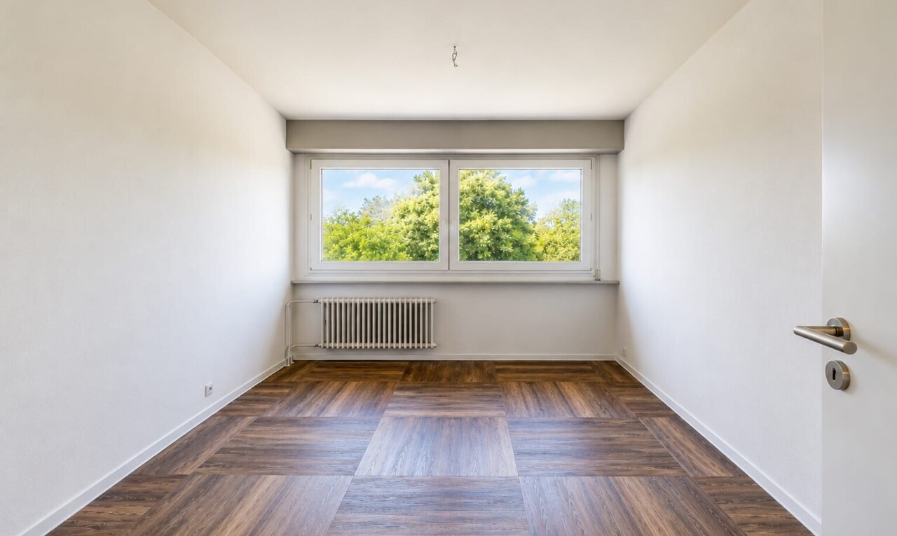 pièce vide avec radiateur, drywall, cloison sèche, wood finish floor, et sol en finition bois