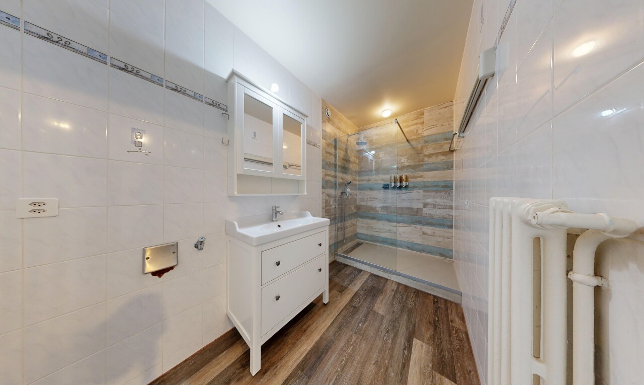 salle de bains avec tile wall, mur en carrelage, miroir, douche, et salle de bain complète