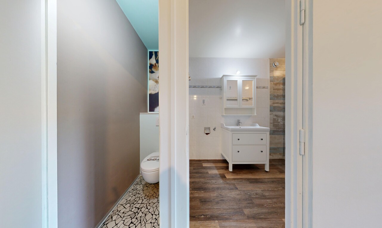 salle de bains avec miroir, lavabo (ou coiffeuse selon le contexte), sol en finition bois, wood finish floor, et inside property