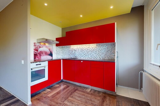 cuisine avec radiateur, dosseret, backsplash, four, et red cabinets