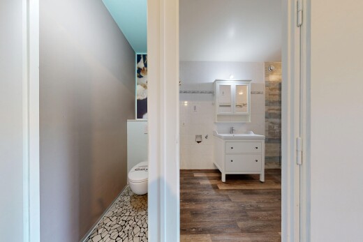 salle de bains avec miroir, lavabo (ou coiffeuse selon le contexte), sol en finition bois, wood finish floor, et inside property
