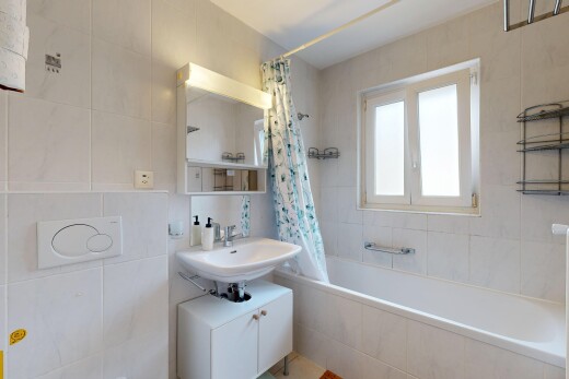 salle de bains avec miroir, mur en carrelage, tile wall, salle de bain complète, et lumière naturelle