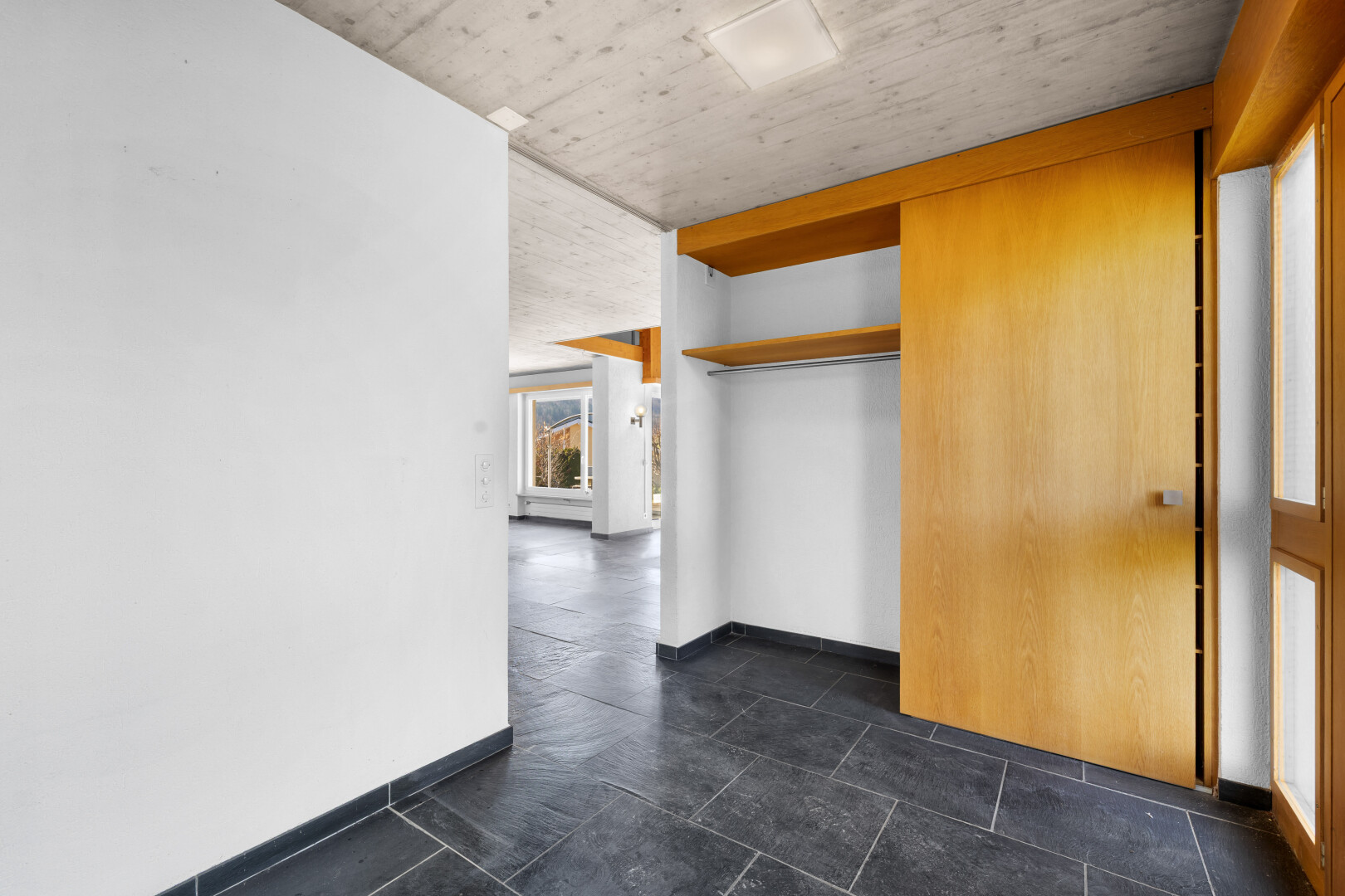 pièce vide avec cloison sèche, drywall, dark floor, inside property, et plafond en béton