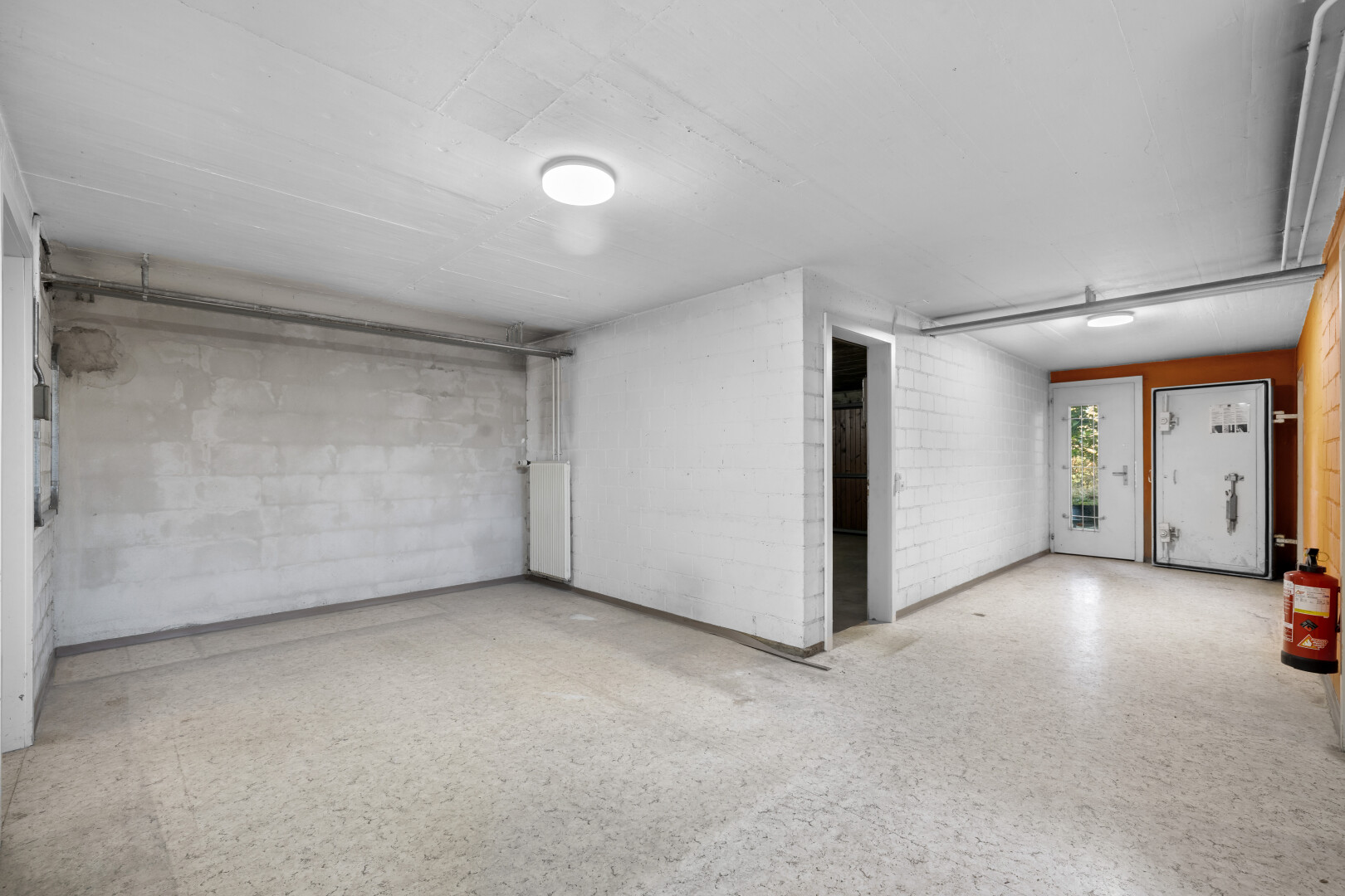 pièce vide avec inside property, mur en blocs de béton, concrete block wall, radiateur, et sous-sol
