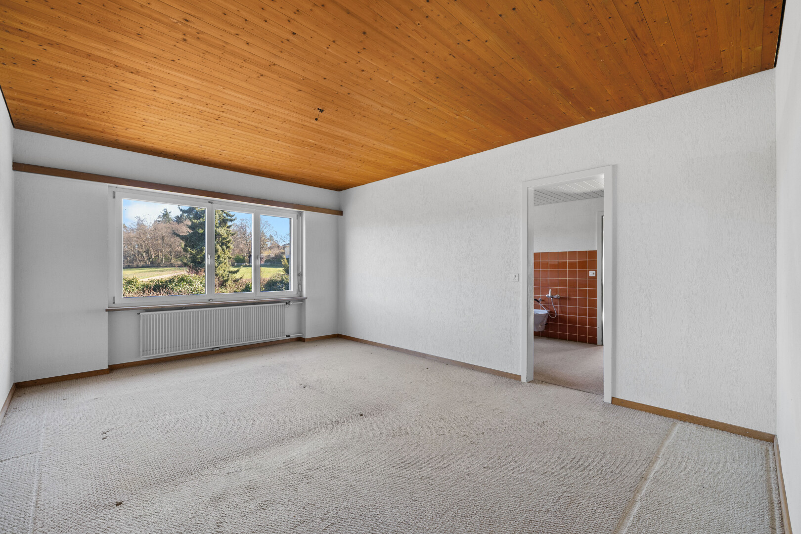 pièce vide avec day time, radiateur, wood ceiling, plafond en bois, et natural light
