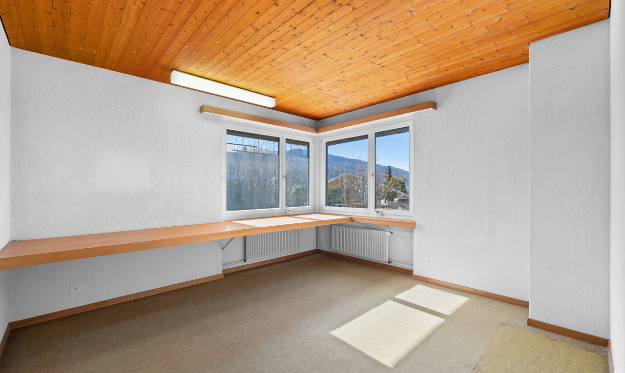 pièce vide avec moquette, carpet, plafond en bois, wood ceiling, et radiateur