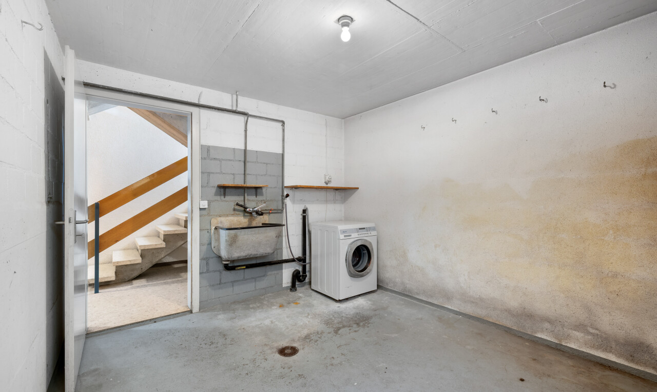 buanderie avec sol en béton, concrete floor, lave-linge et sèche-linge, unfinished concrete floor, et inside property