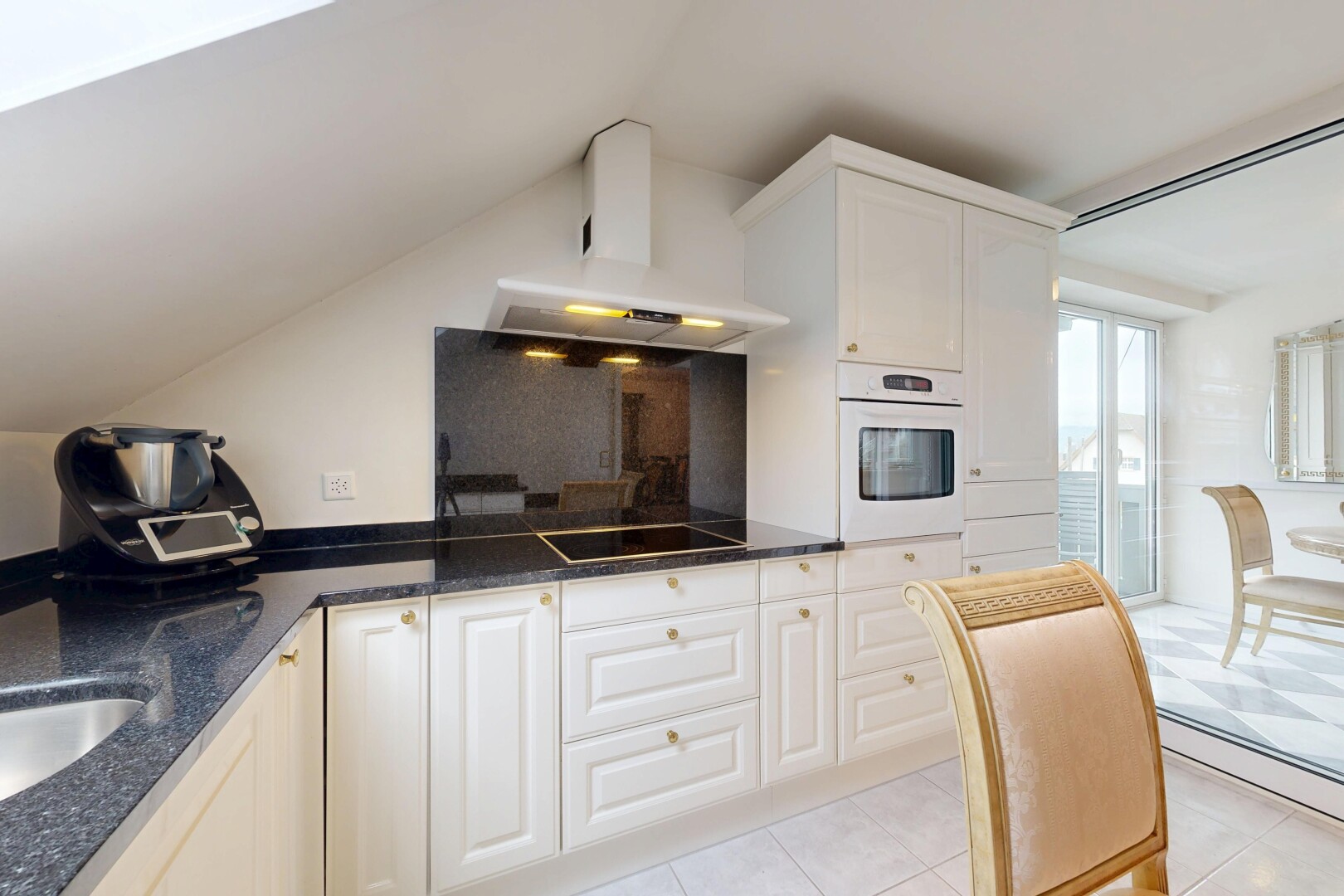 cuisine avec dark countertops, hotte, four, light floor, et armoires blanches