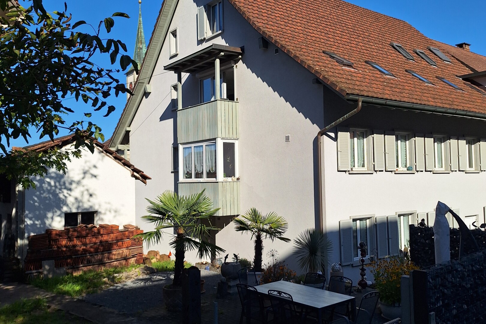 façade avec day time, bardage en stuc, terrasse, et coin repas extérieur