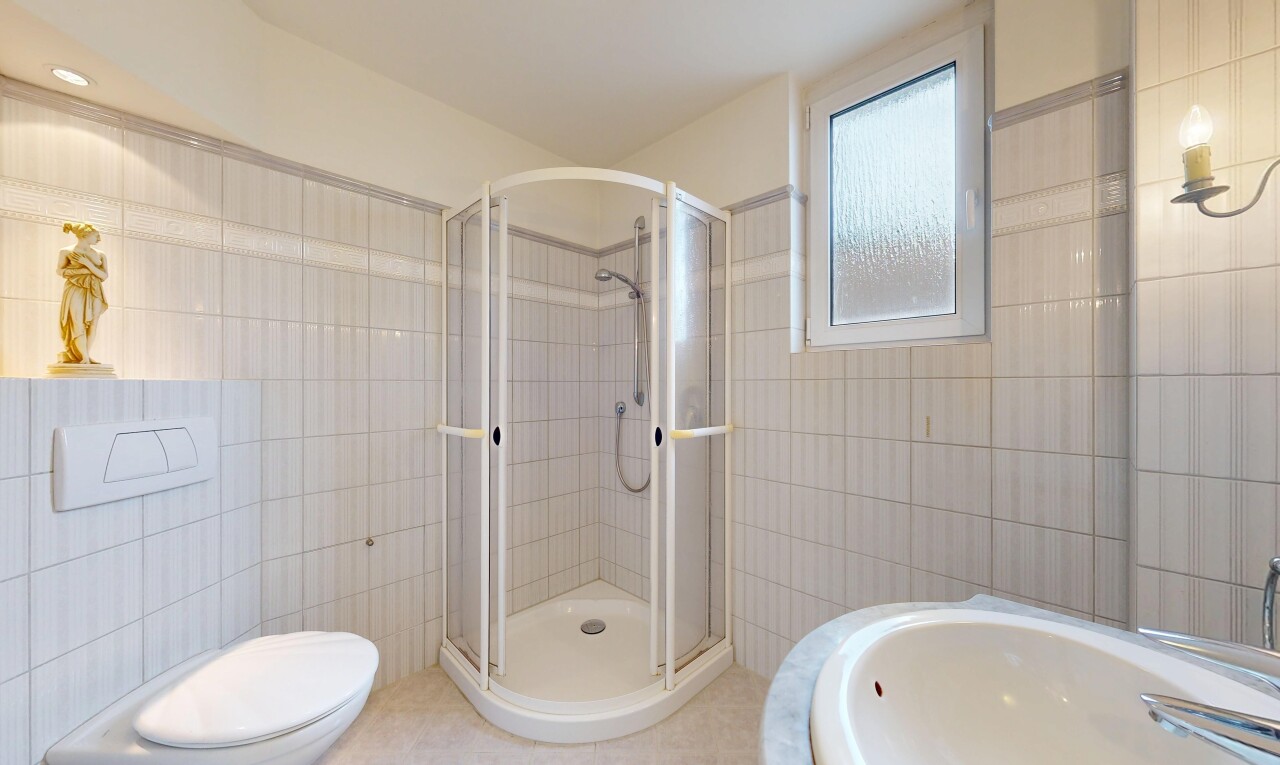 salle de bains avec tile wall, mur en carrelage, douche, salle de bain complète, et inside property