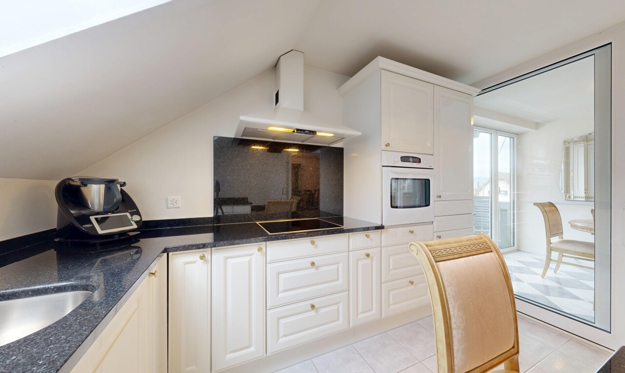 cuisine avec dark countertops, hotte, four, light floor, et armoires blanches