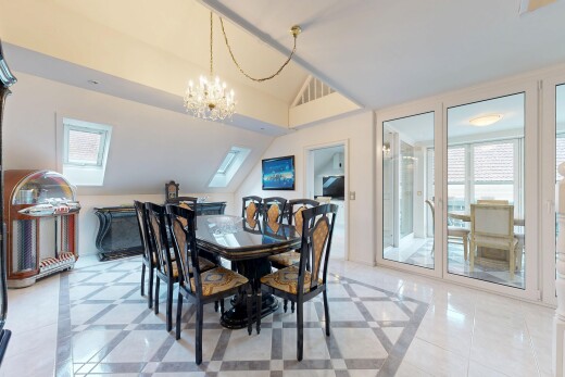 dining space with inlaid floor details, lofted ceiling, hanging lights, and light tile patterned floors