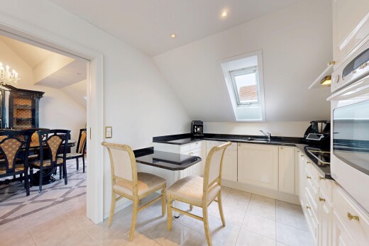 cuisine avec plafond voûté, vaulted ceiling, four, light floor, et dark countertops