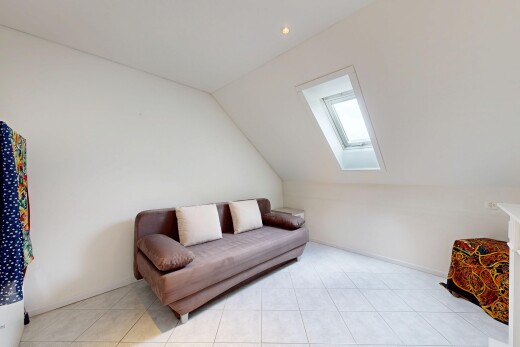 living room featuring a skylight, lofted ceiling, and light tile patterned floors